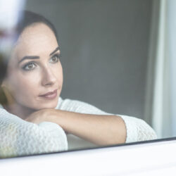loneliness-impact-quarantine-during-pandemic-makes-sad-woman-look-out-from-window